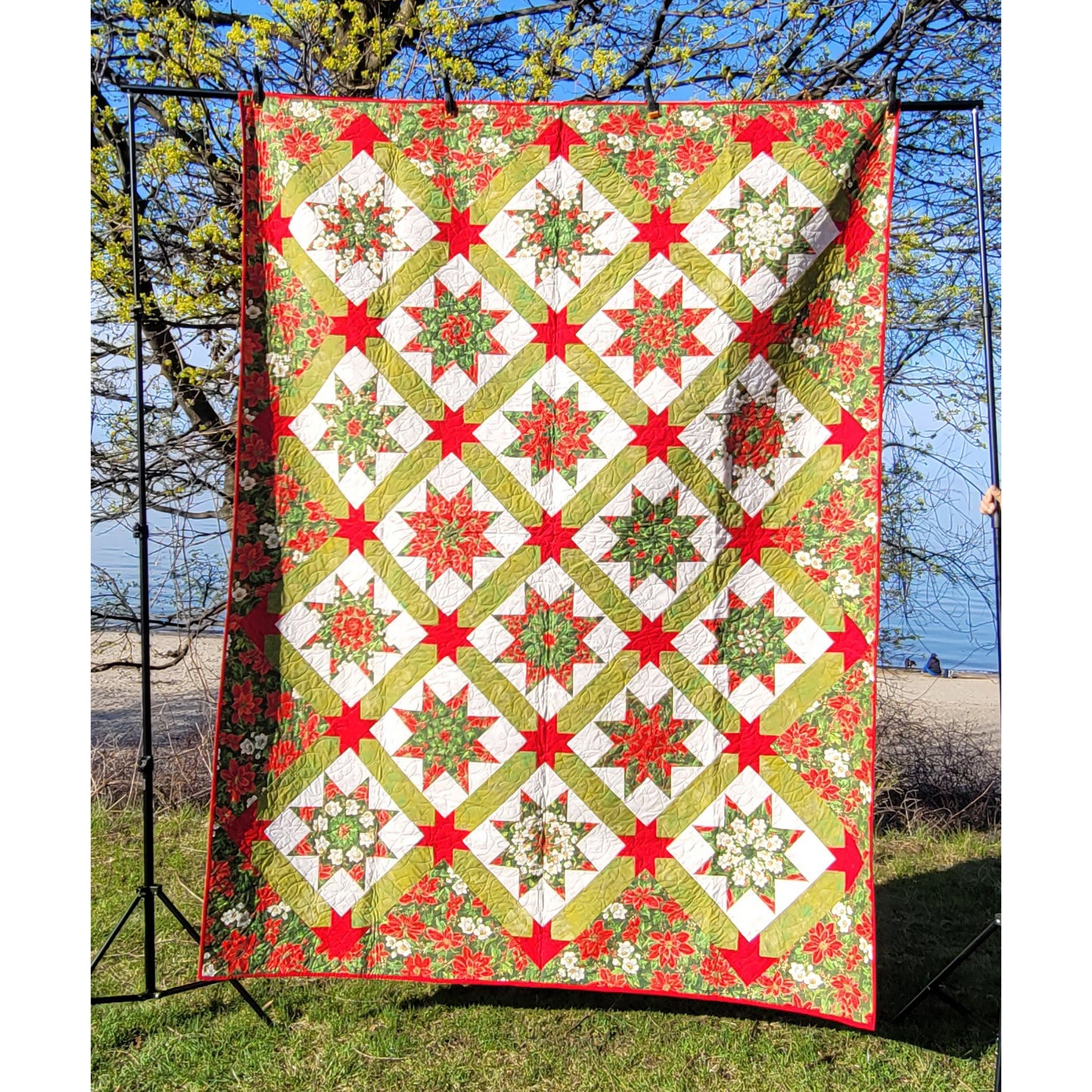 Poinsettia Passion quilt pattern uses Kaleidoscope LeMoyne Stars set on point and sashed with stars for cornerstones.