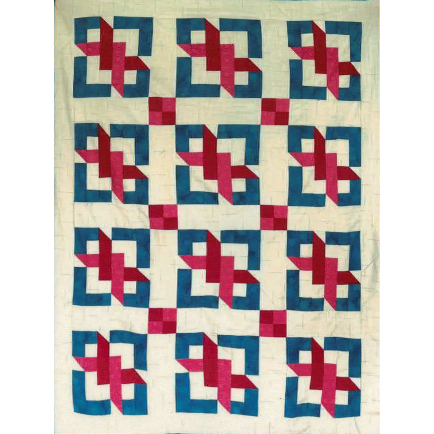 Quilt with geometric pattern of blue and pink shapes on a white background