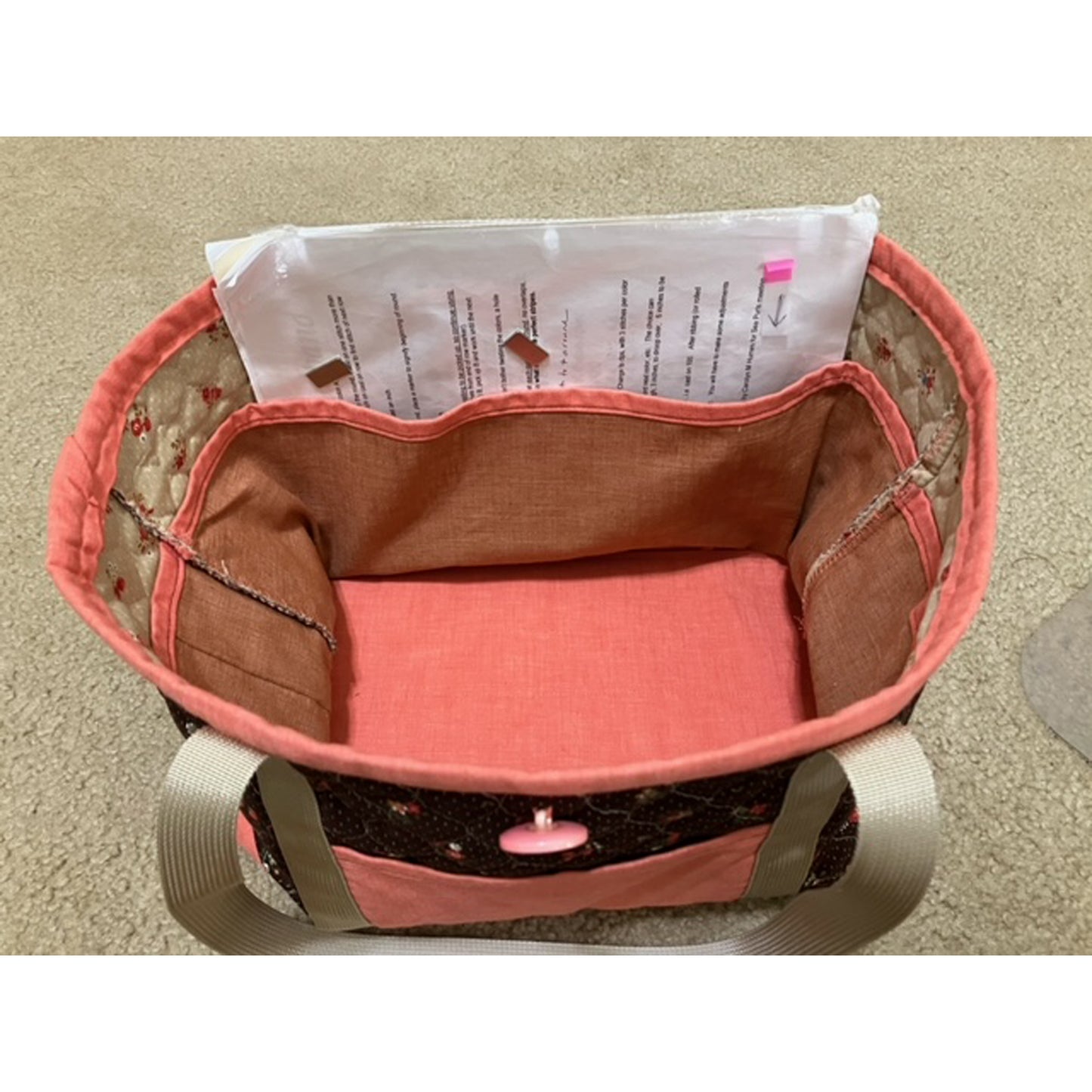 Inside of bag shown in black and pink. Large pockets inside which is shown with printed instructions.