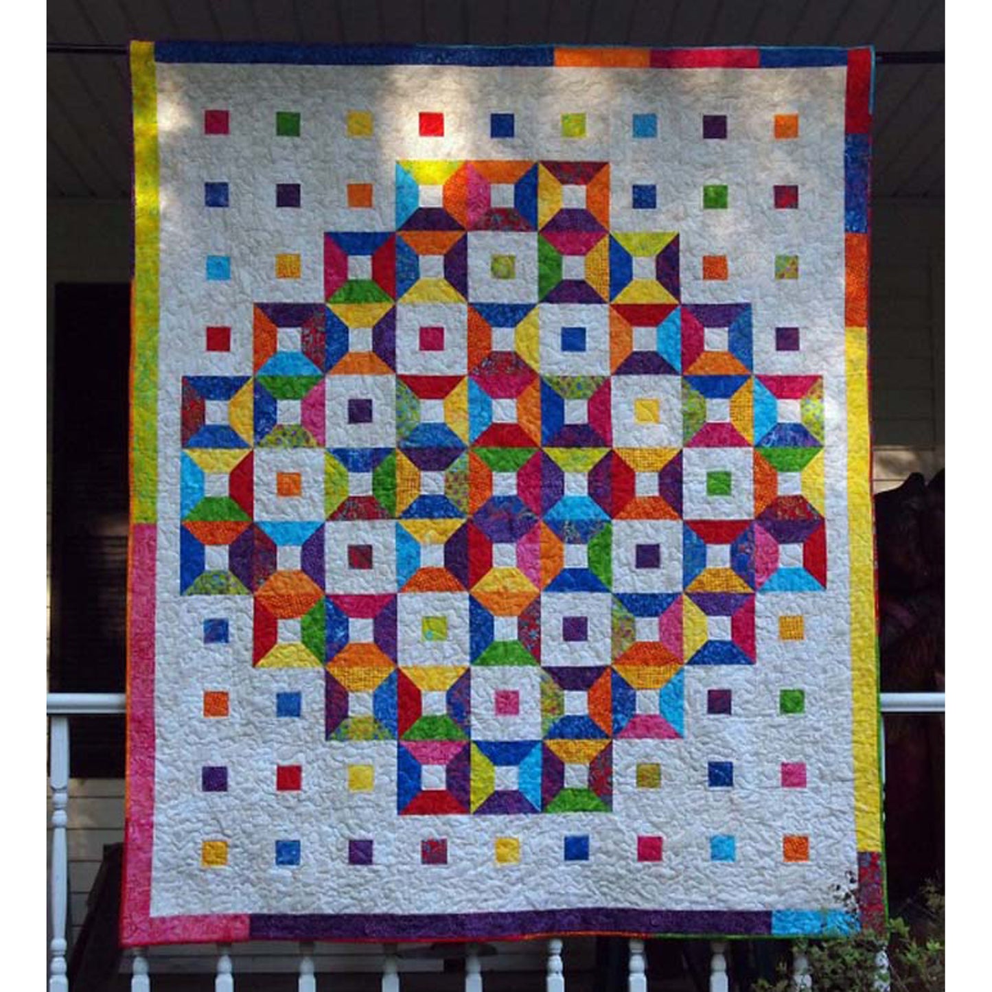 Fun and bright quilt features boxes and squares of fun colors on a white background.