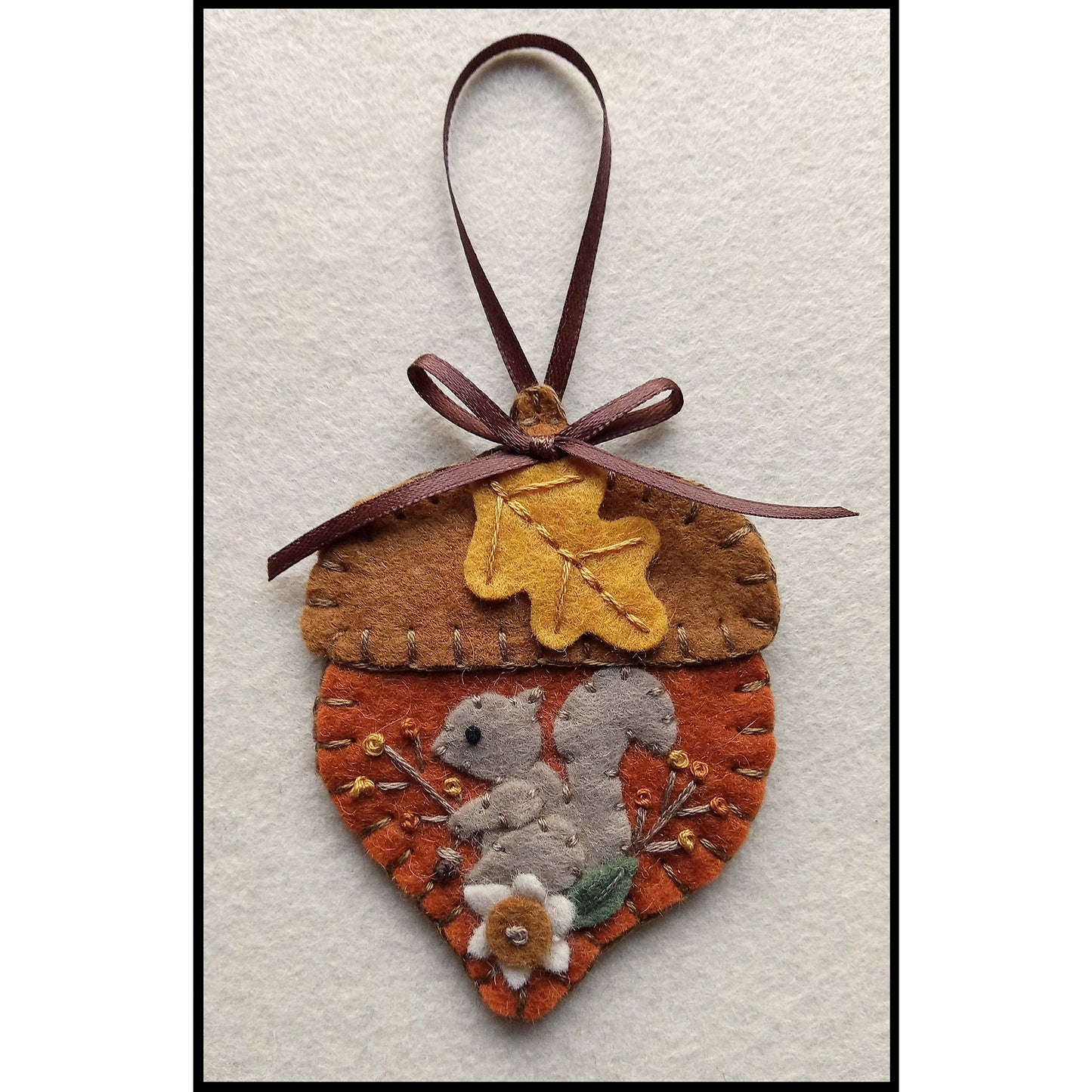 Close up of squirrel ornament on an acorn design.