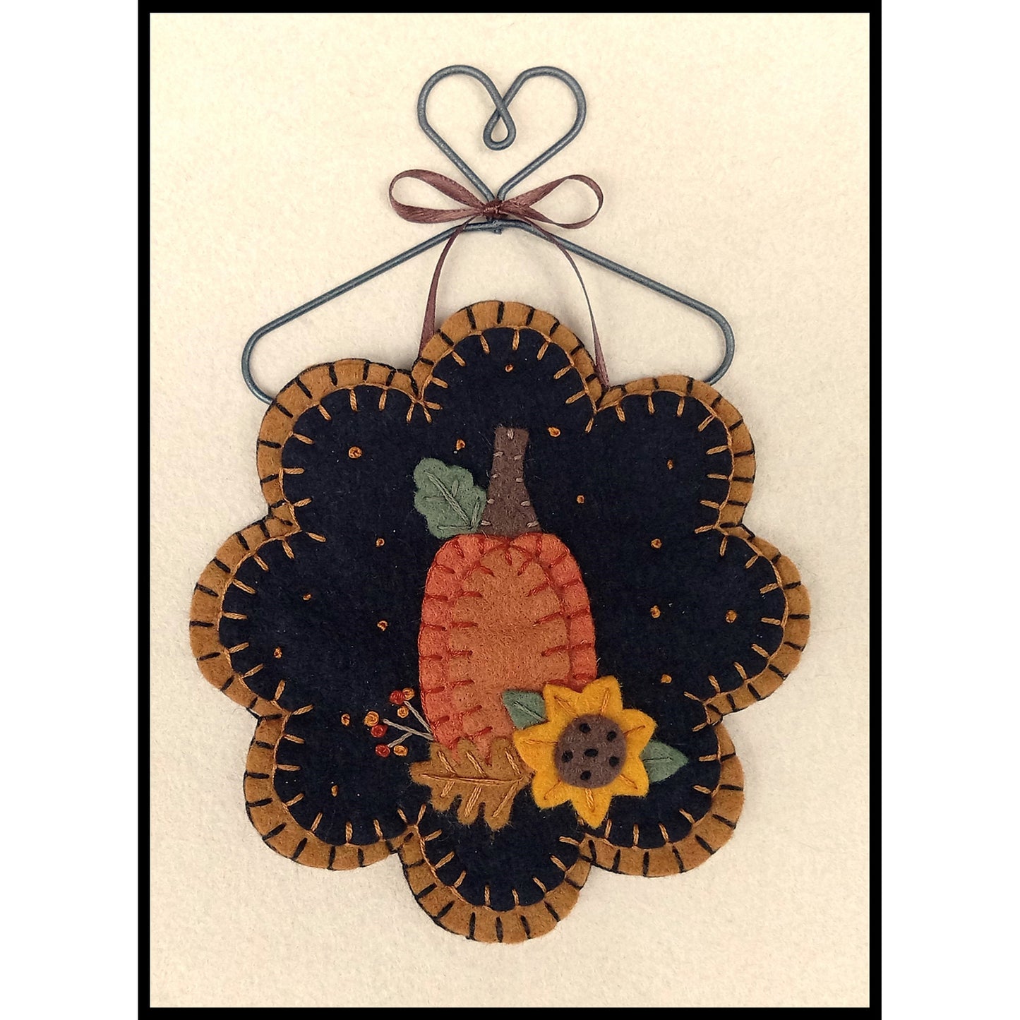 Adorable pumpkin with sunflower ornament.
