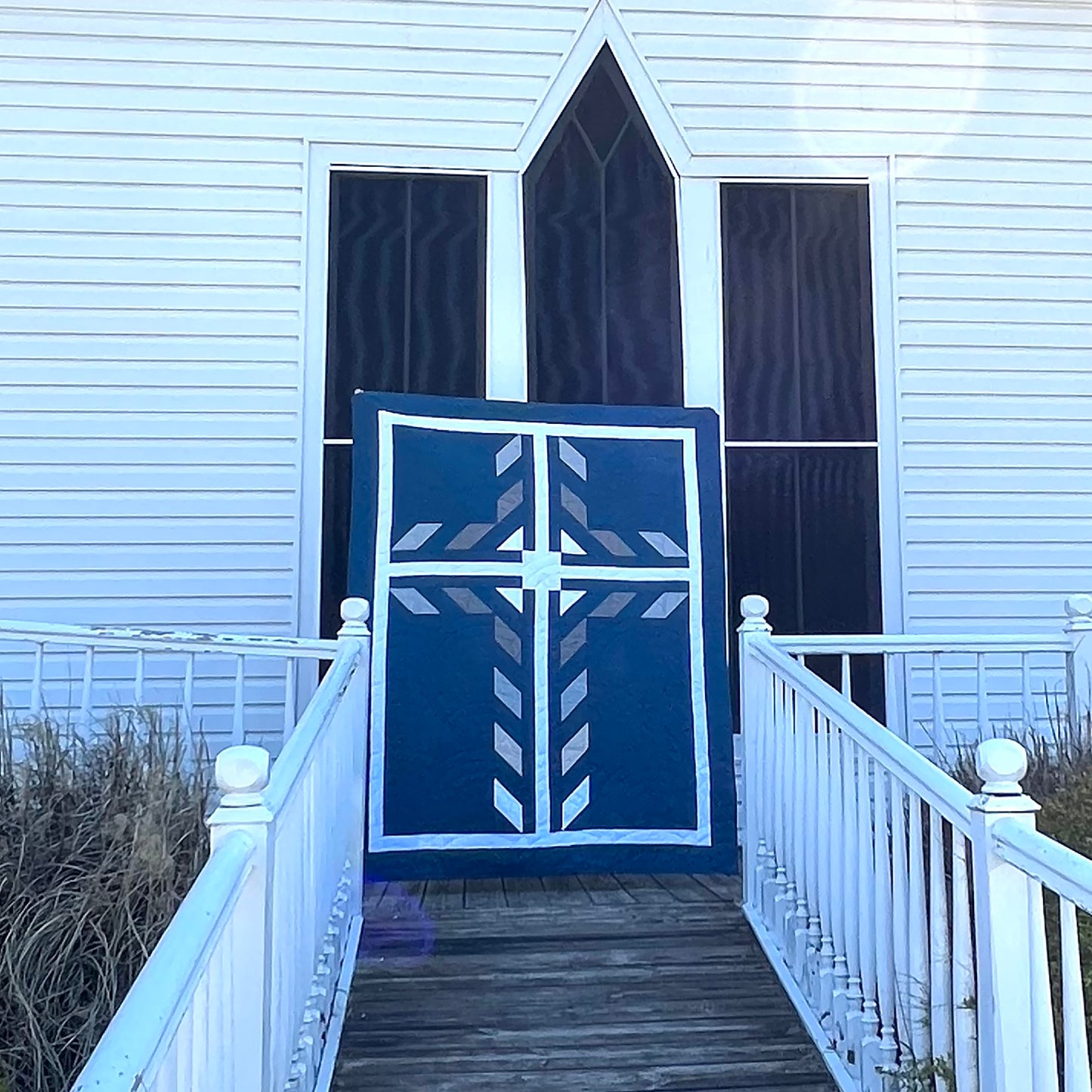Beautiful cross quilt in two shades of blue and white with a darker background. Very classy.