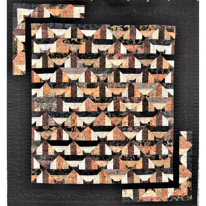 Geometric patterned quilt with brown, black, and white colors on a dark background