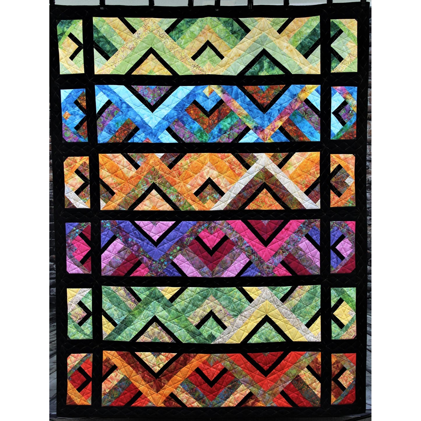 Colorful geometric quilt with a black border on a white background