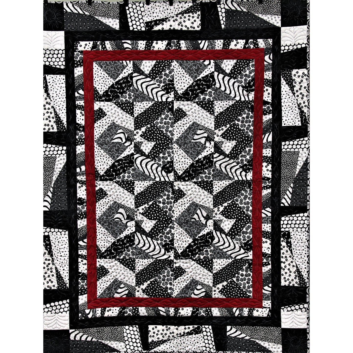 Quilt with geometric pattern and red border on a white background
