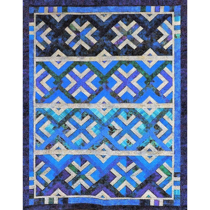 Quilt with geometric pattern in blue, black, and white on a dark background