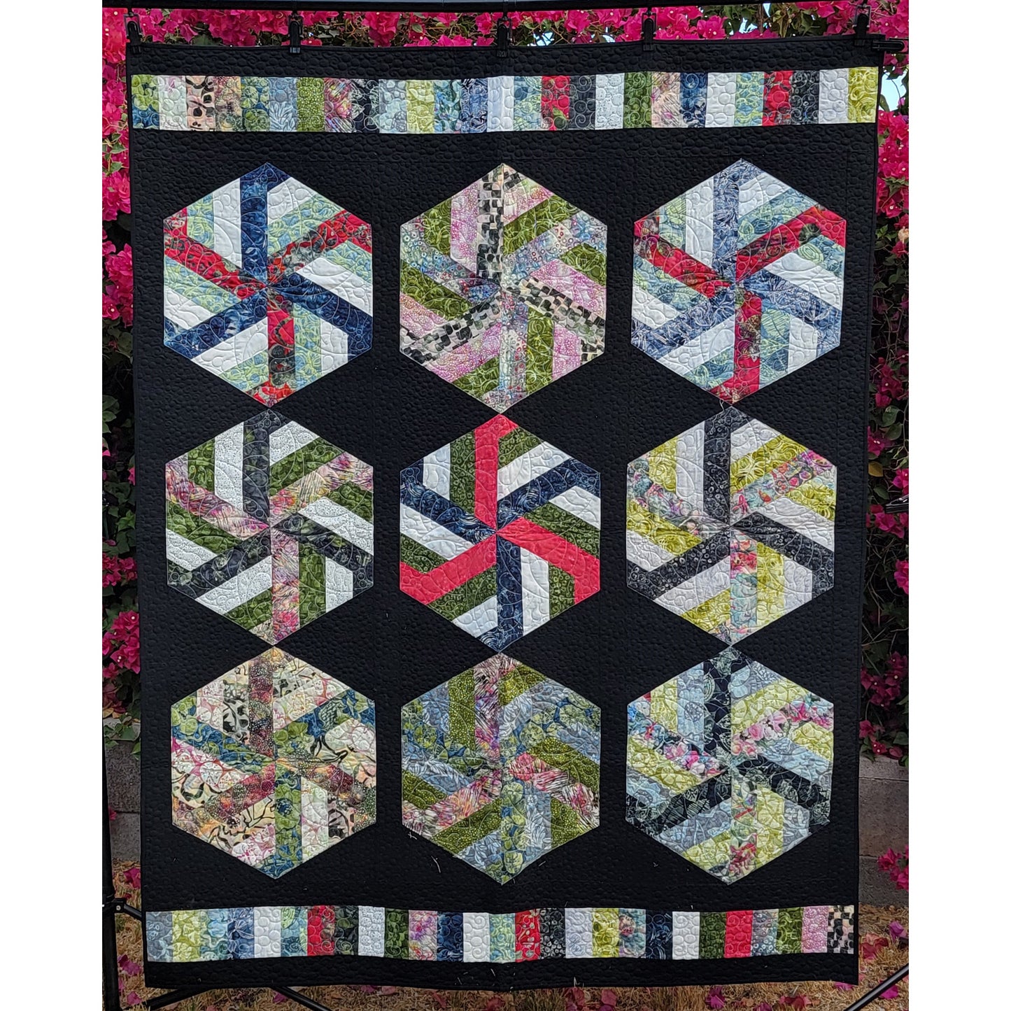 Hexagonal quilt pattern with colorful fabric pieces on a black background