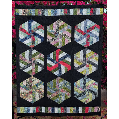 Hexagonal quilt pattern with colorful fabric pieces on a black background