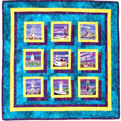 Quilt with nine square panels featuring lighthouse images on a blue background