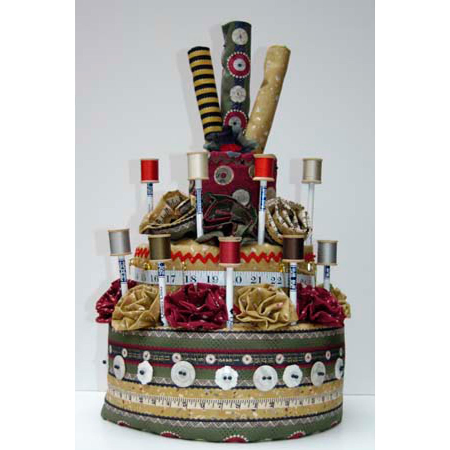 Decorative fabric "cake" with various items on a white background