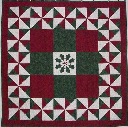 Festive quilt in only red, green and white fabric. The center features a poinsettia design with the border in pinwheel blocks.