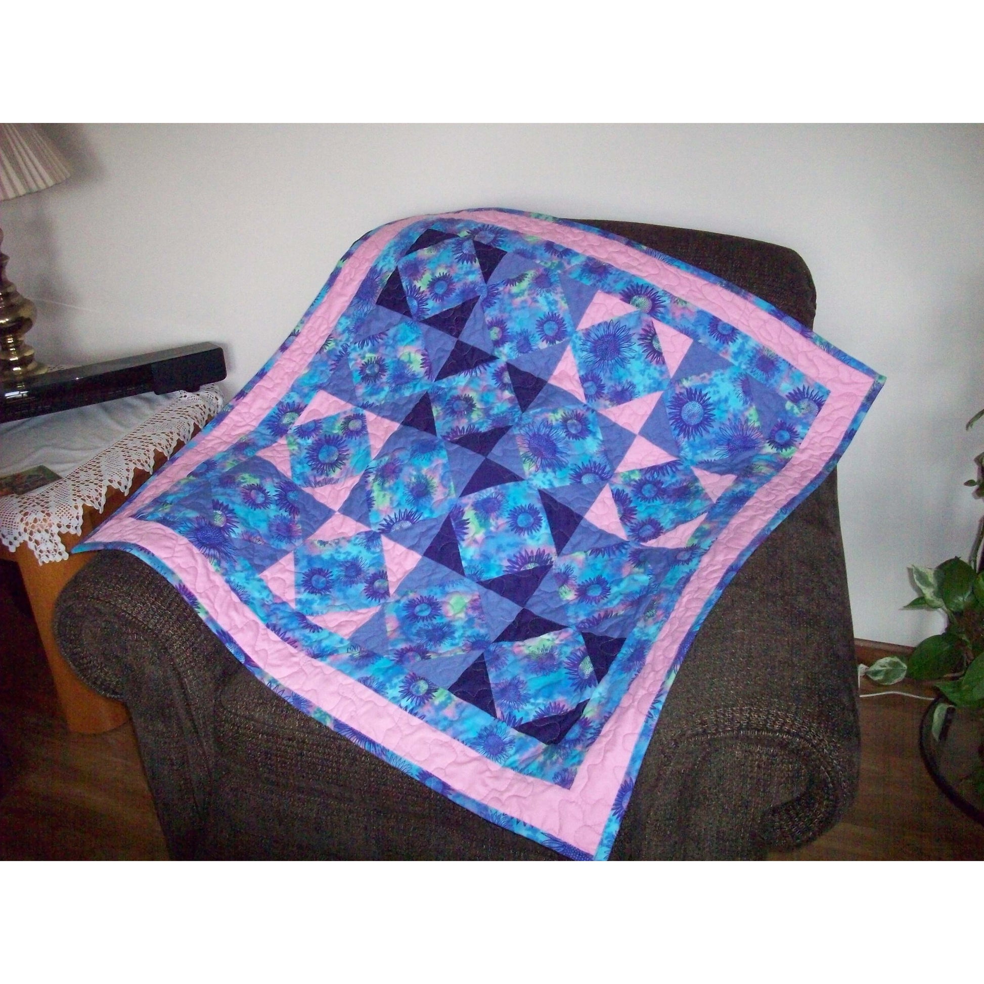 Blue and pink diamond quilt draped over a chair.