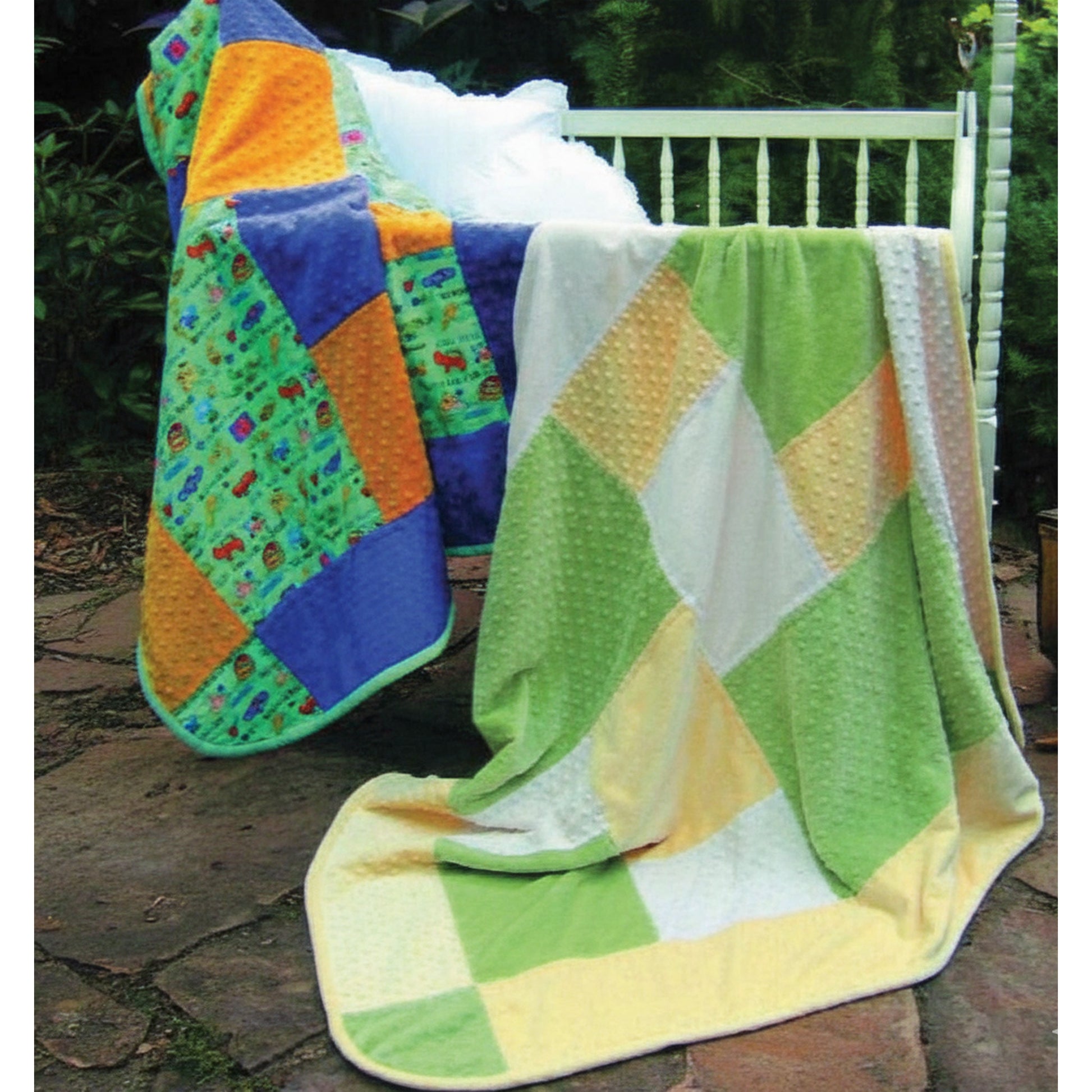 Nighty Night is an adorable baby-sized quilt. Just choose 3 fabrics, and you're ready to go.  Two options shown draped over a crib.