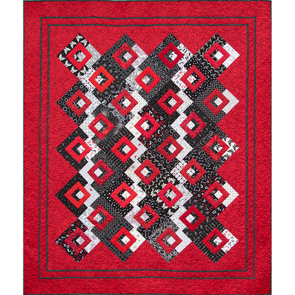 Bright quilt features red background and popping red diamonds on a black and white fabric middle of rows of diamonds.