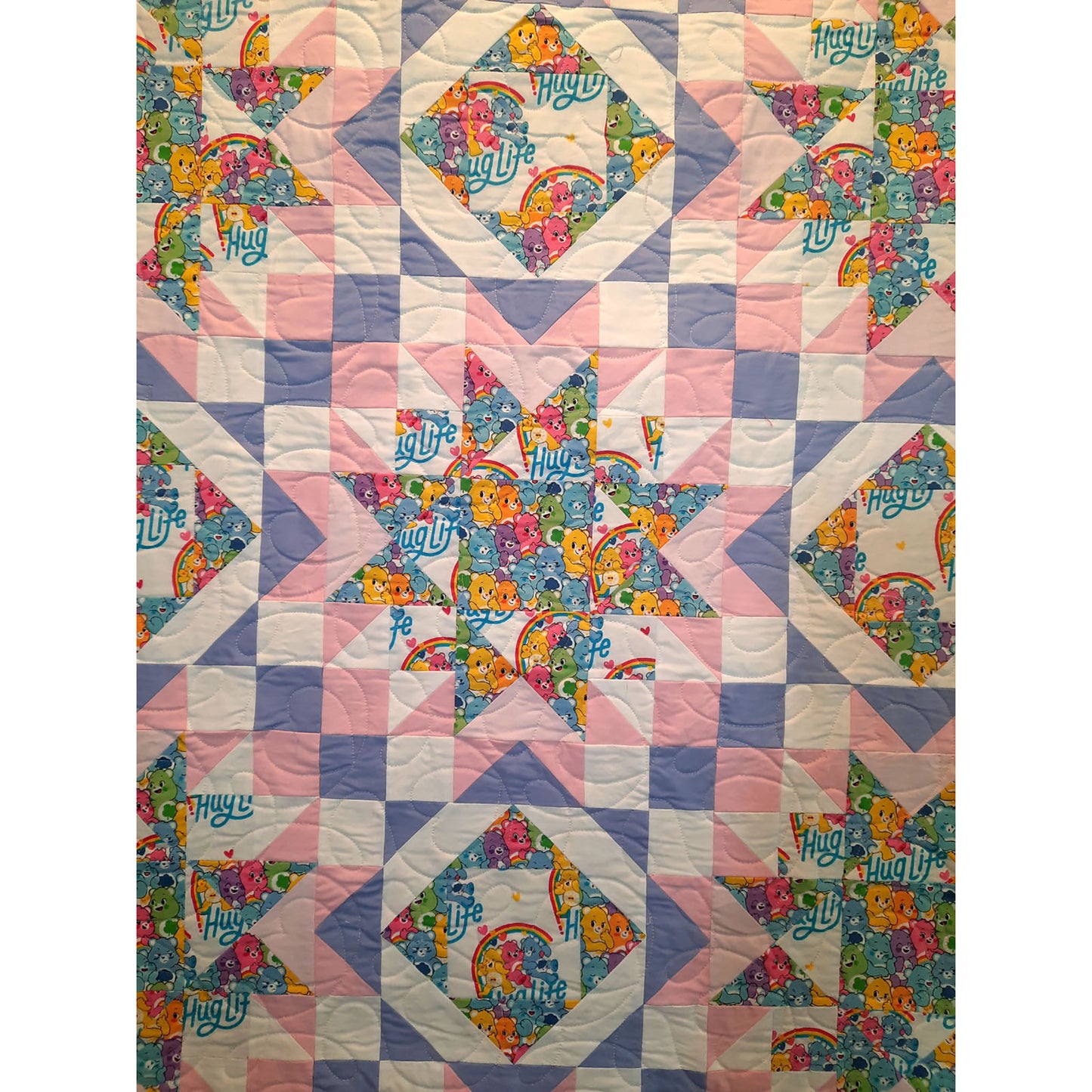 Hug Life quilt features two blocks one star and one diamonds inside each other. This version has bright bear fabric and complimenting pink, purple, and white solid fabric.  Showing a closeup of the star so you can see how the focus fabric can shine.