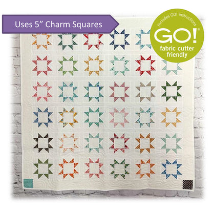 Beautiful start blocks with empty centers quilt on white background. Image shares that this is a Accuquilt Go! pattern and uses 5-inch charm squares.