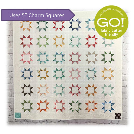 Beautiful start blocks with empty centers quilt on white background. Image shares that this is a Accuquilt Go! pattern and uses 5-inch charm squares.