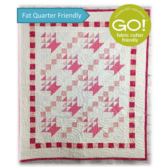 Pink and White quilt with baskets in  diagonal rows with upside down triangles inside to make them look like flowers and a border of small squares.