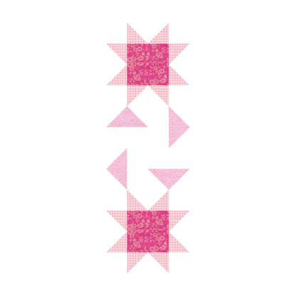 A pink and white table runner featuring a star pattern. 