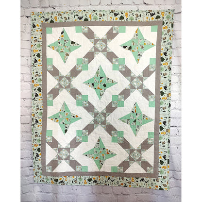 A geometric quilt featuring a harmonious blend of green and gray patterns.