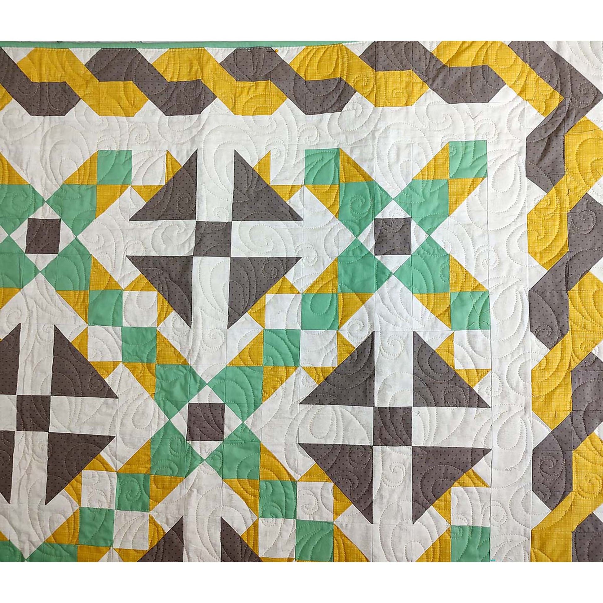 Corner of beautiful quilt in green and yellow with brown accents. Triangle brown flowers with rows between of green and yellow and braided looking border in brown and yellow. Focusing more on the braid on top and right.