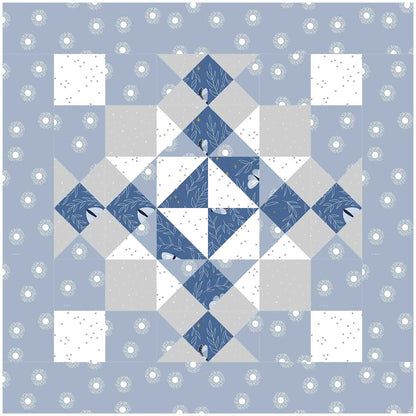 A quilt featuring a pattern of blue, white, and gray squares arranged in a harmonious design. One block shown.