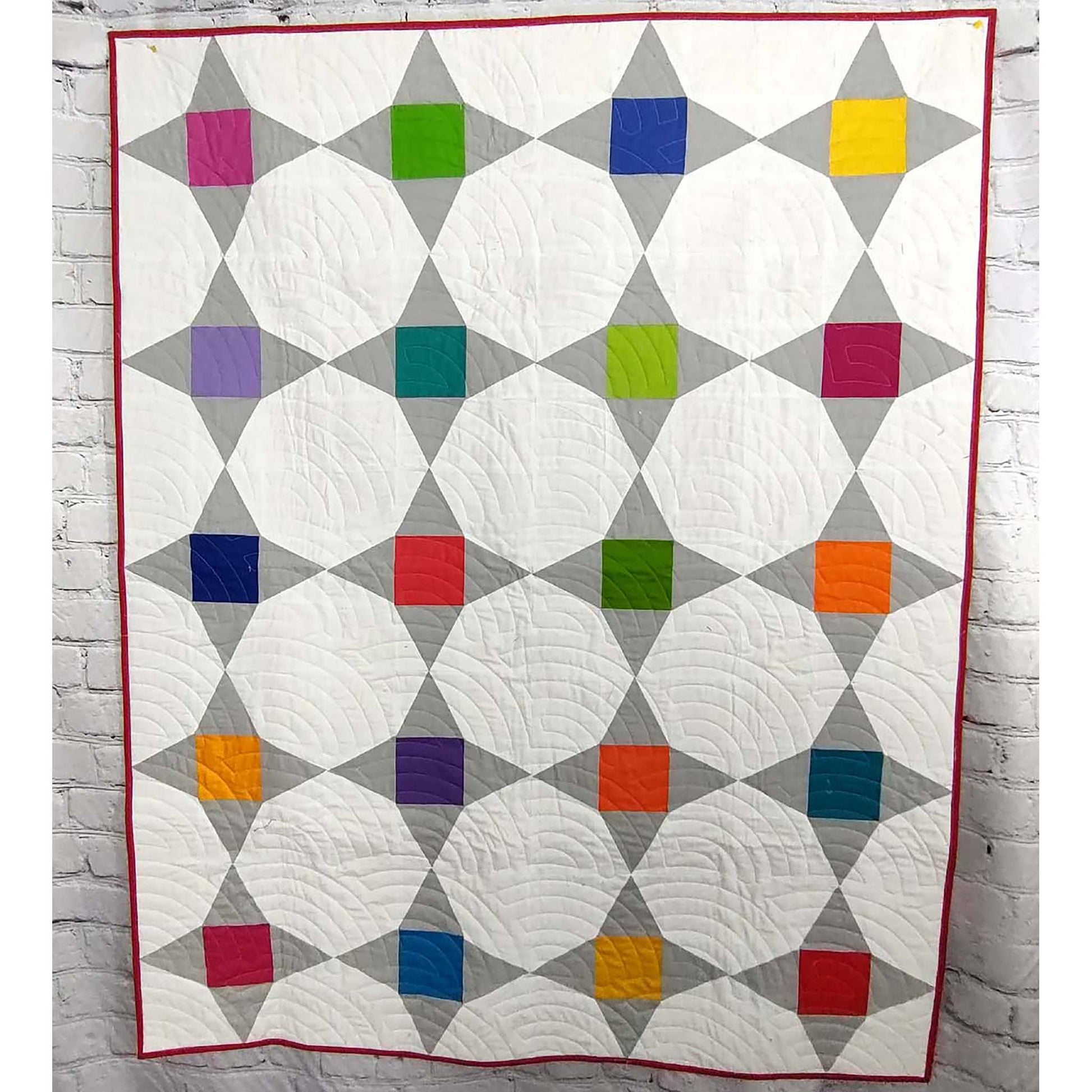 Friendship star quilt features bright colored blocks in the middle of each star with gray as the points and white background fabric.