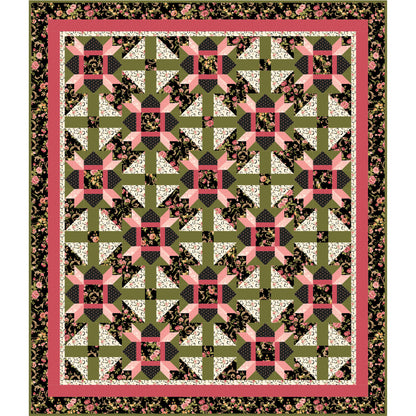 Quilt with geometric pattern in green, pink, and black on a white background