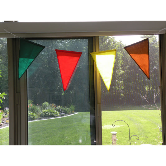 Four colorful pennants showcased in front of a window.