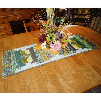 Table with a fall fabric table runner with flowers on it.