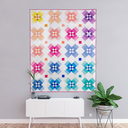 Intermediate quilt pattern with modern geometric vibe, featuring color gradation from light to dark. Ideal for fat quarters, precuts, and scraps.