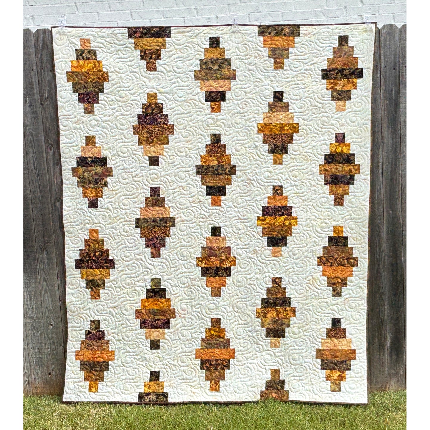 Floating Lanterns quilt shows off those fabric strips! - in this picture they are in shades of brown with a cream background fabric.