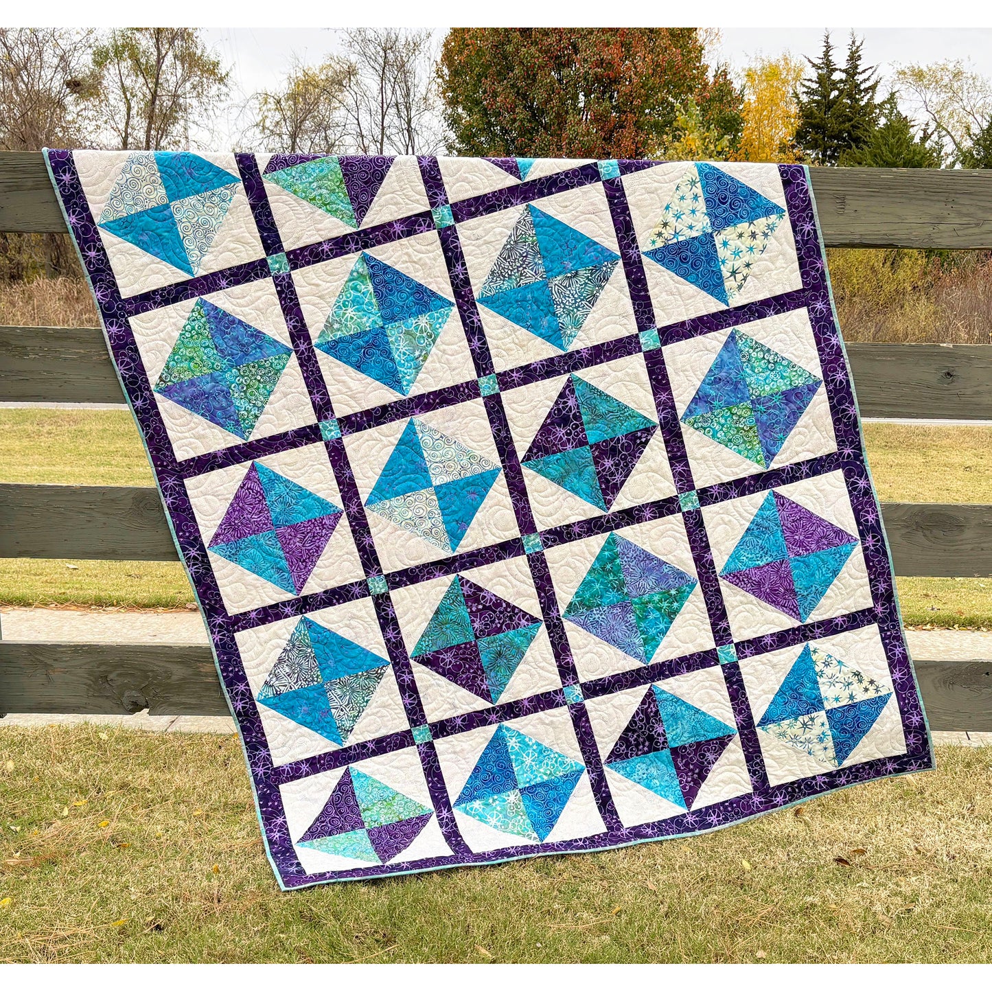 Beautiful quilt features squares of two colors in an hourglass design inside cream squares with darker border to help it all pop.