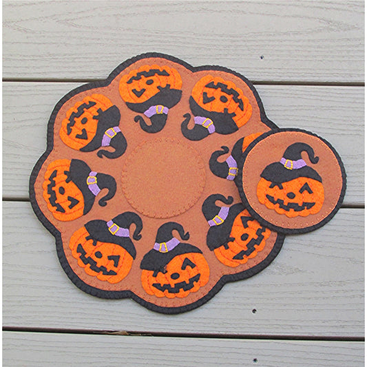 Festive candle mat and coaster feature jack o'lanterns with witches hats.