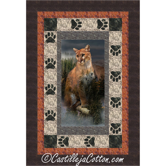 Quilt with a cougar design in the center, surrounded by paw prints and a brown border.
