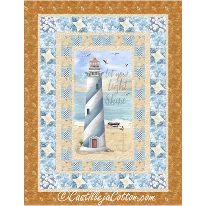 Center fabric panel quilt featuring a lighthouse on a sandy beach surrounded by borders made from simple blocks and pieced stars.