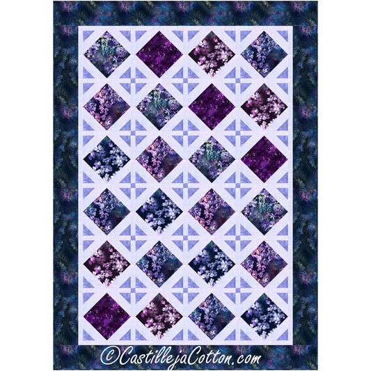 Bright quilt features diamond design. Half of the diamonds are filled with fabric in purple flowers. The other half are decorative diamonds made of triangles pointed in with a small square in the middle.