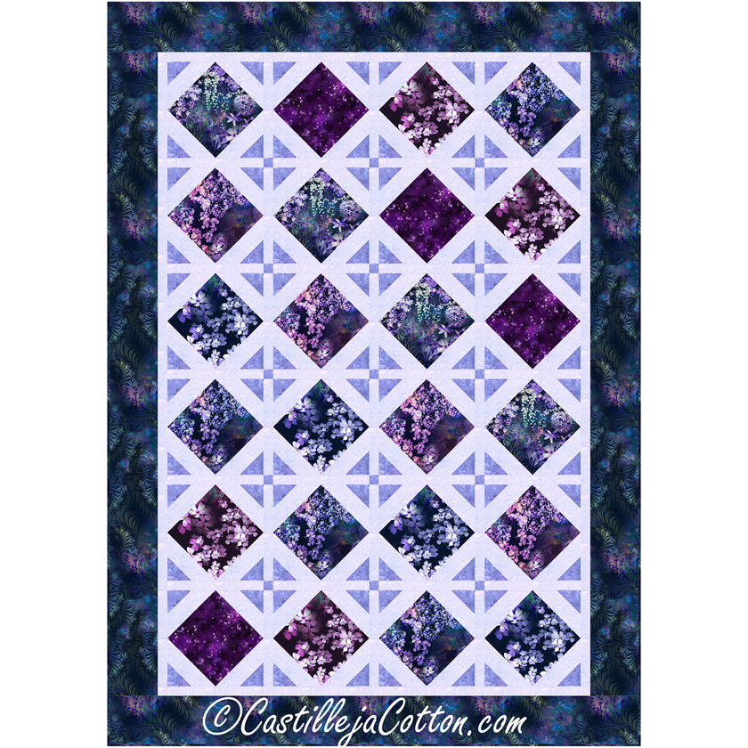 Bright quilt features diamond design. Half of the diamonds are filled with fabric in purple flowers. The other half are decorative diamonds made of triangles pointed in with a small square in the middle.