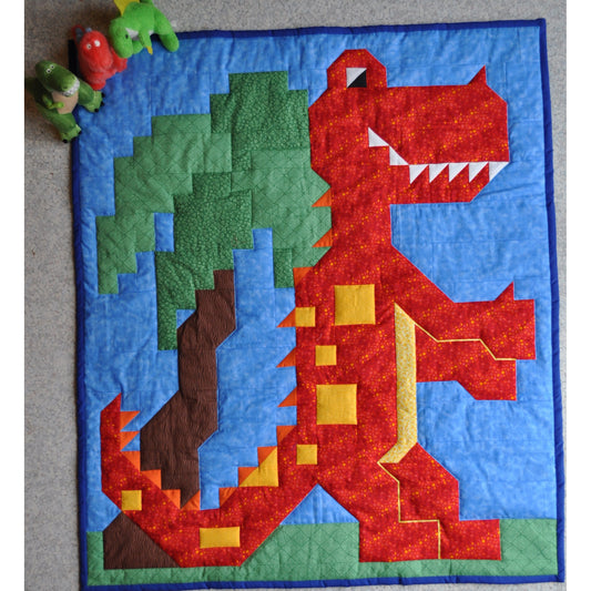 Dinosaur/T-rex quilt features a happy dinosaur and a tree.