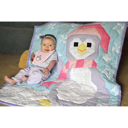 Penguin quilt and a baby the quilt features a large penguin with snow and wearing a hat and scarf.