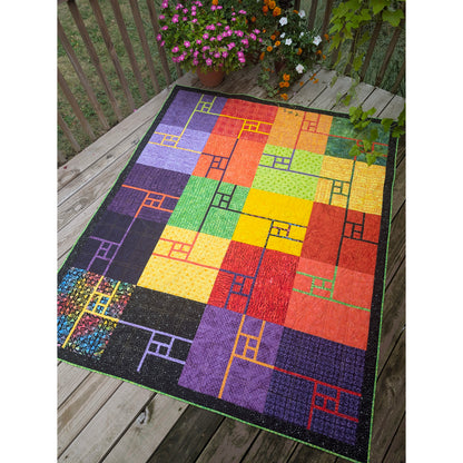 Beautiful quilt features blocks of colored fabric, broken up with some lines and rectangles in different colors.