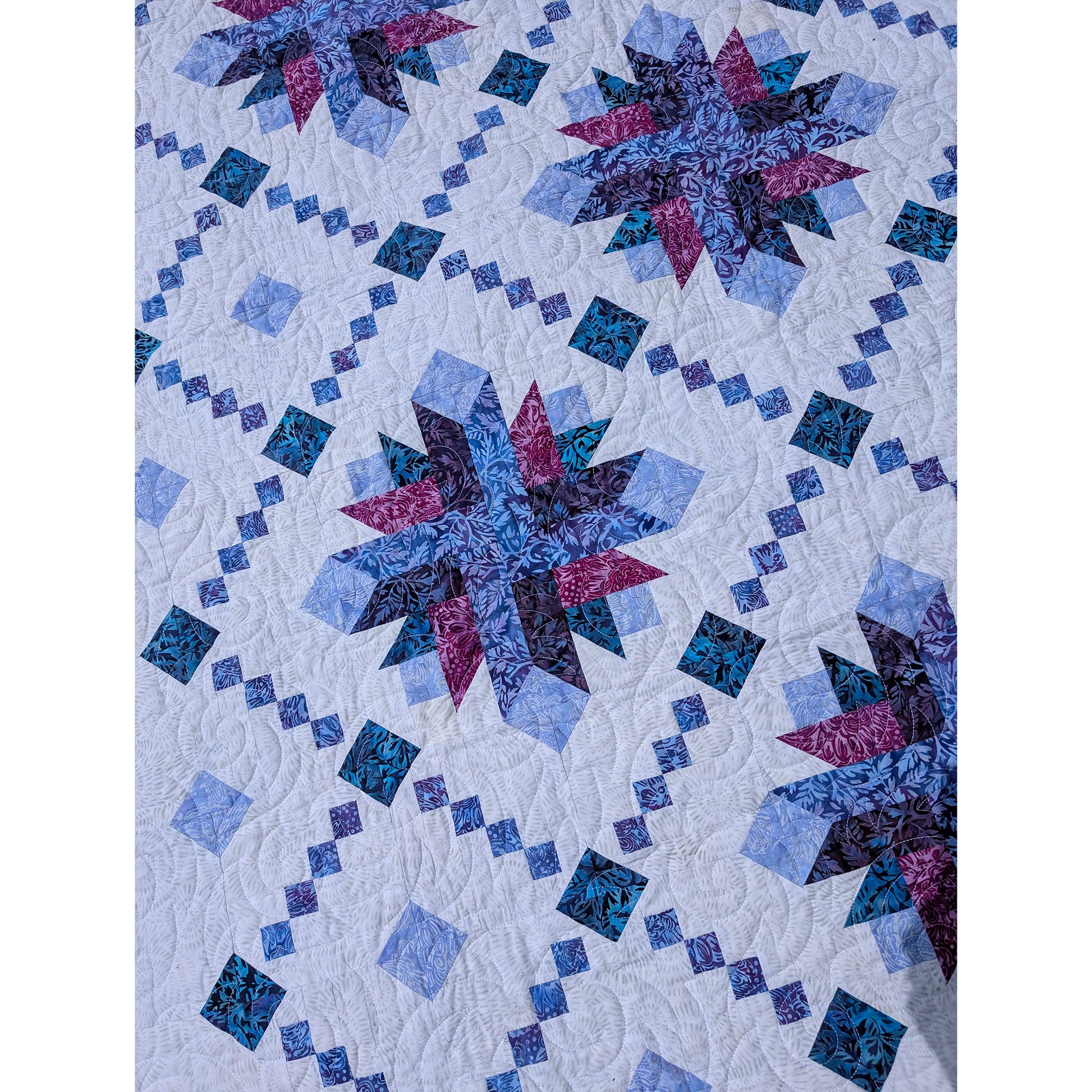 Close up image of shining Lace quilt featuring delicate strip-pieced chains surround elegant starburst blooms. 