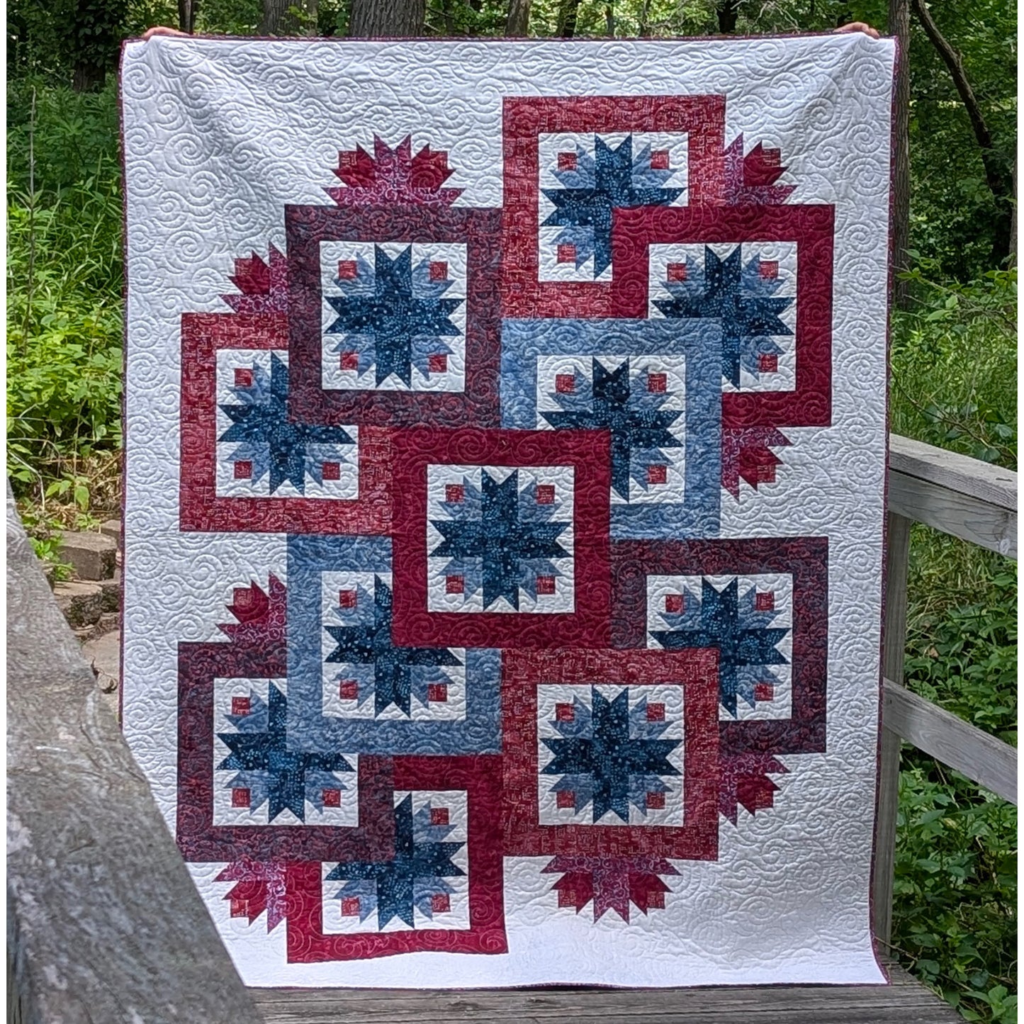 Beautiful and fun quilt features overlapping star blocks with bold and wide borders to help with the overlapping look. A few additional stars peek out here and there outside those blocks to give a peek-a-boo effect.