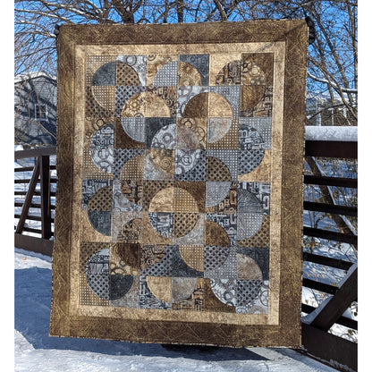 Quilt features neutral colors of fabric with overlapping circles broken into 4 fabrics.
