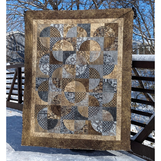 Quilt features neutral colors of fabric with overlapping circles broken into 4 fabrics.