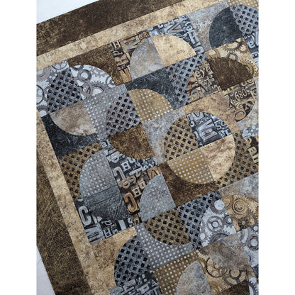 Quilt features neutral colors of fabric with overlapping circles broken into 4 fabrics.