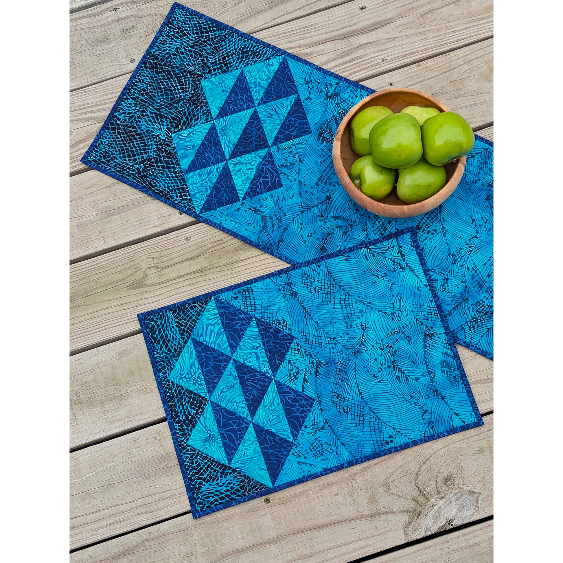 Simple clusters of HST units set on point are the focal point of this elegant, quilted table pattern.  Shown here in blues.  One side of the place mat has the half-square-triangles and the other is a solid fabric. Table runner has the design on both sides with lots of space in the middle for run quilting.