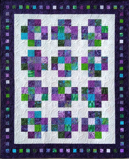 Beautiful scrappy quilt in purple and green.