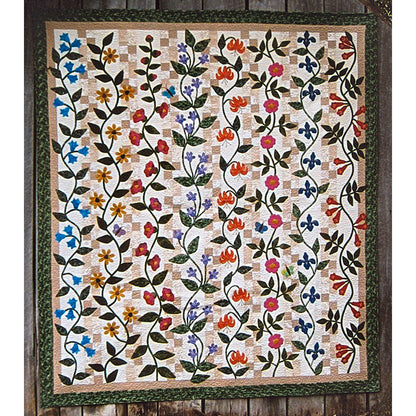 Beautiful quilt features rows of different flowers in their vines on top of a checker row in light tan. 